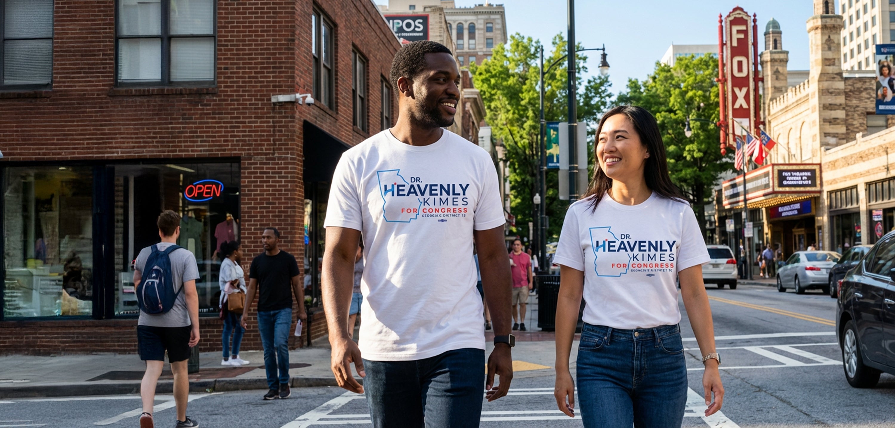 Two people walking on a city street wearing 'Heavenly' t-shirts.